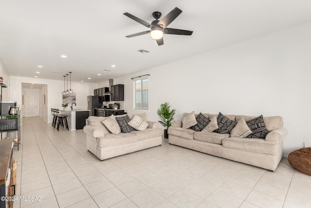 tiled living room featuring ceiling fan and sink