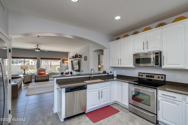 kitchen featuring white cabinetry, sink, kitchen peninsula, and appliances with stainless steel finishes