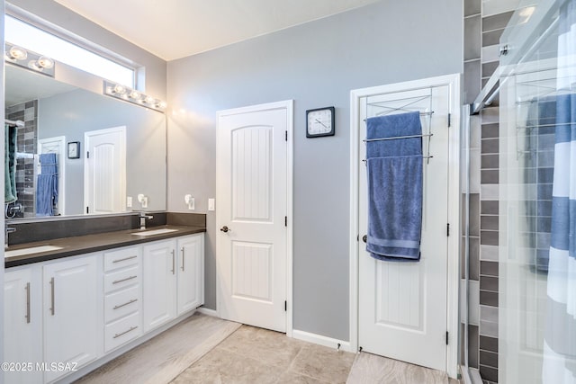 bathroom featuring tile patterned flooring, vanity, and a shower with door