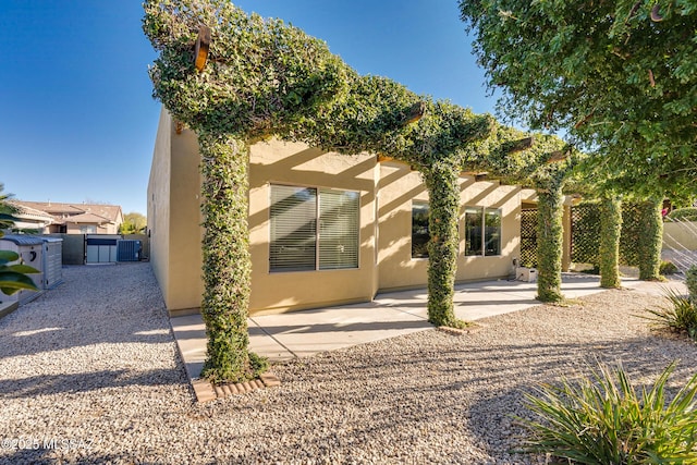 rear view of property featuring a patio and central air condition unit