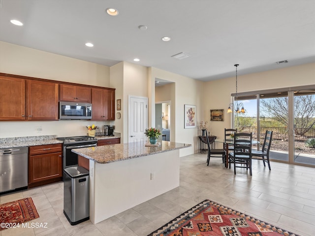 kitchen featuring pendant lighting, a center island, light stone counters, stainless steel appliances, and a chandelier