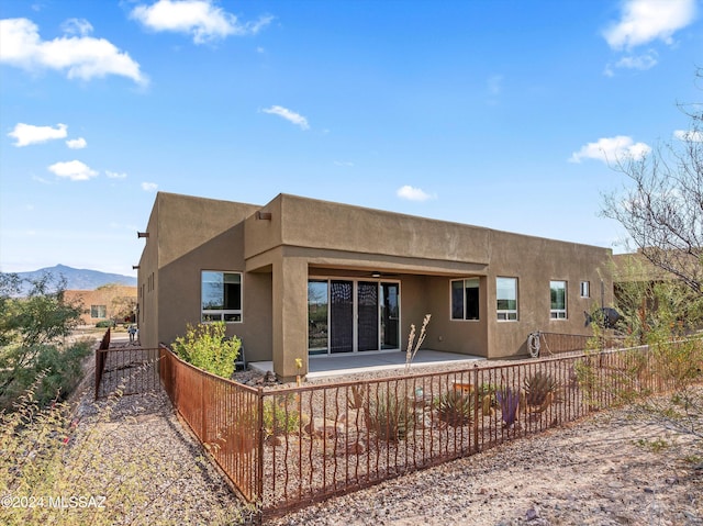 rear view of house featuring a mountain view and a patio