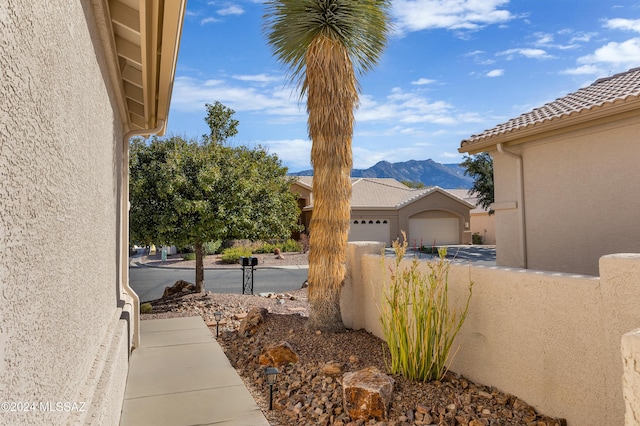 view of side of property with a mountain view and a garage