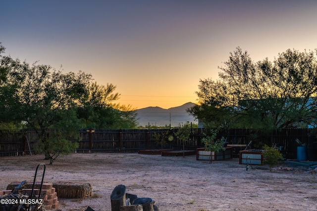 view of yard with a vegetable garden, a fenced backyard, and a mountain view