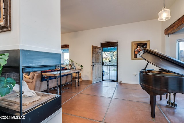 foyer featuring finished concrete flooring, plenty of natural light, and baseboards