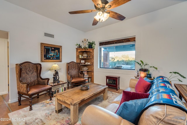 living room featuring baseboards, visible vents, and a ceiling fan