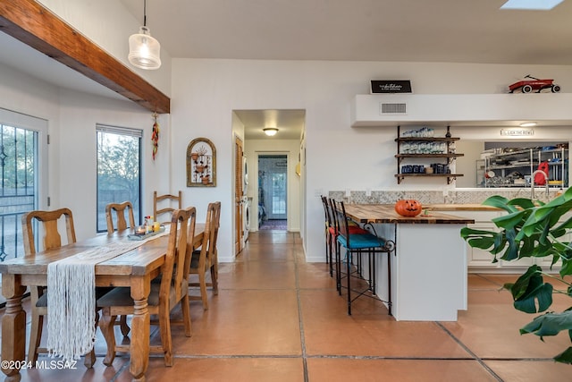 dining area with baseboards, visible vents, and concrete flooring