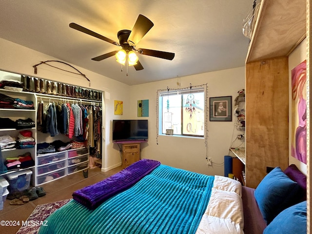 tiled bedroom featuring ceiling fan and a closet