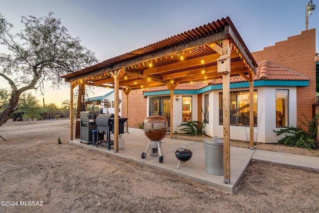 patio terrace at dusk featuring grilling area