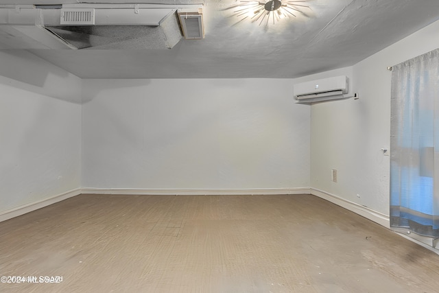 unfurnished room featuring a wall mounted AC, visible vents, and baseboards