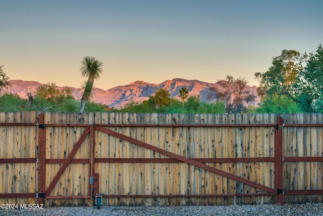 view of gate with fence and a mountain view