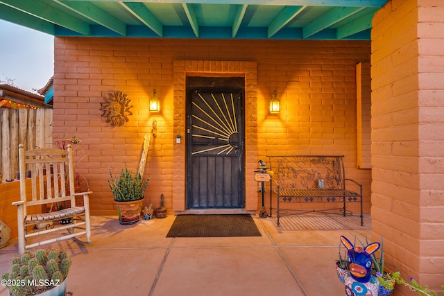 entrance to property featuring brick siding