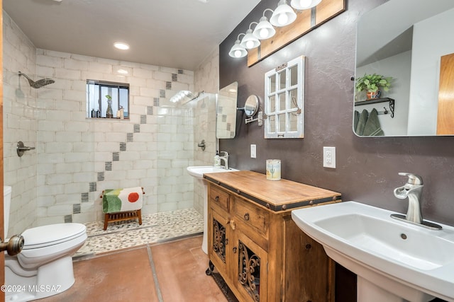 bathroom featuring tile patterned flooring, sink, toilet, and tiled shower