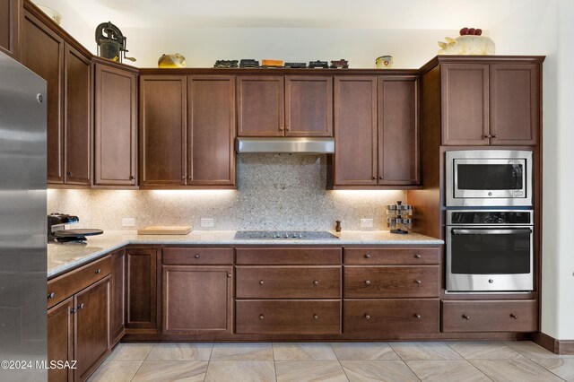 kitchen with backsplash, a center island with sink, a kitchen breakfast bar, sink, and stainless steel appliances