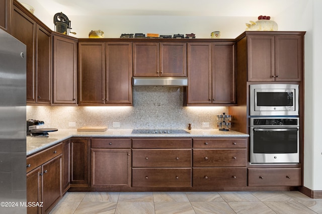 36513 S Cactus Ln, Tucson, AZ 85739 - kitchen with under cabinet range hood, backsplash, appliances with stainless steel finishes, and light stone counters