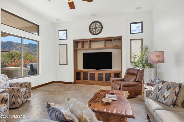 living room featuring a mountain view, light tile patterned flooring, and ceiling fan