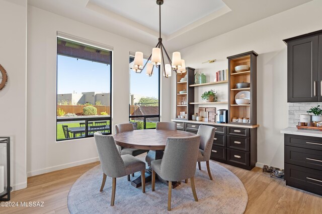 kitchen featuring a center island with sink, wall chimney exhaust hood, decorative backsplash, a kitchen bar, and stainless steel appliances