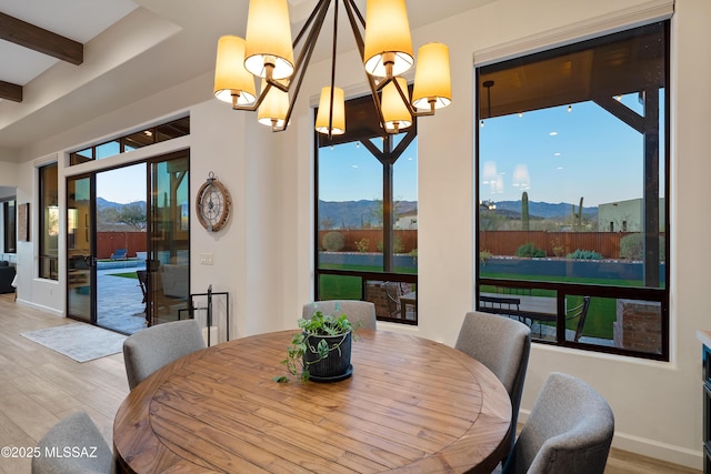 dining area featuring a chandelier, a mountain view, and wood finished floors