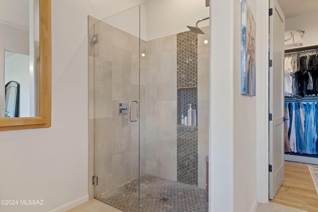 bathroom featuring wood-type flooring and a shower with shower door