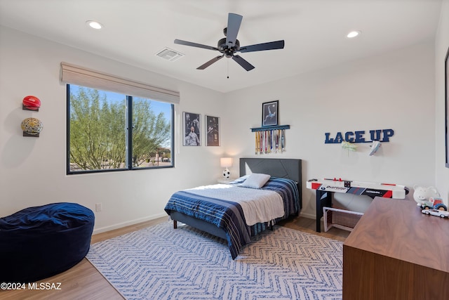 bedroom with baseboards, wood finished floors, visible vents, and recessed lighting