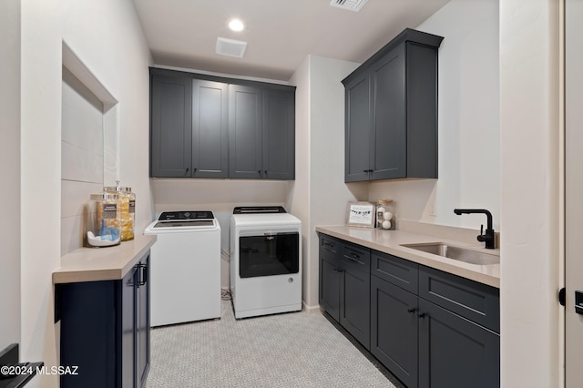 laundry area featuring visible vents, washing machine and clothes dryer, a sink, and cabinet space