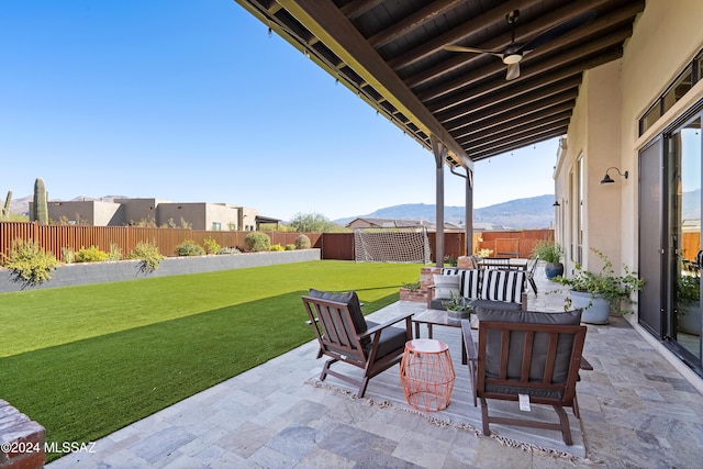 view of patio with an outdoor living space, ceiling fan, and a mountain view