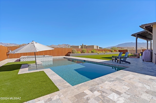 view of swimming pool with a patio area, an in ground hot tub, a yard, and a mountain view