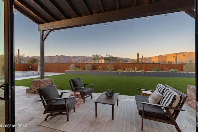 view of patio / terrace with a fenced backyard, a mountain view, and an outdoor hangout area