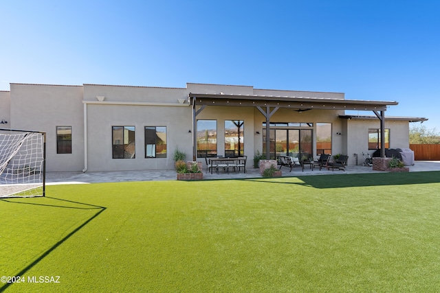 rear view of house with a lawn and a patio area