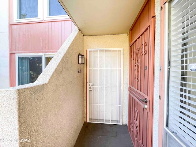 view of exterior entry with a balcony