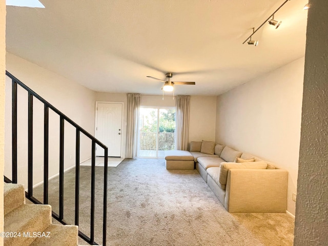 carpeted living room featuring track lighting and ceiling fan