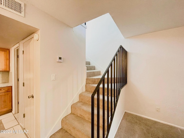 stairway featuring carpet flooring