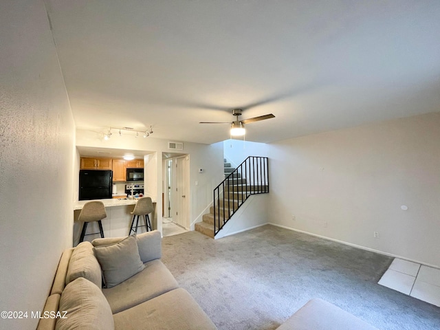 living room featuring ceiling fan, rail lighting, and light colored carpet