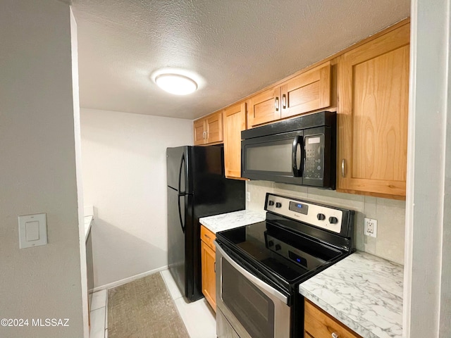 kitchen with backsplash, black appliances, and a textured ceiling