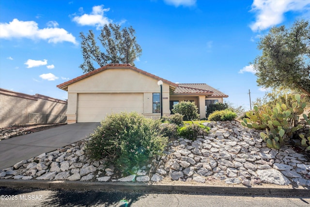 view of front of home featuring a garage, concrete driveway, a tiled roof, and stucco siding