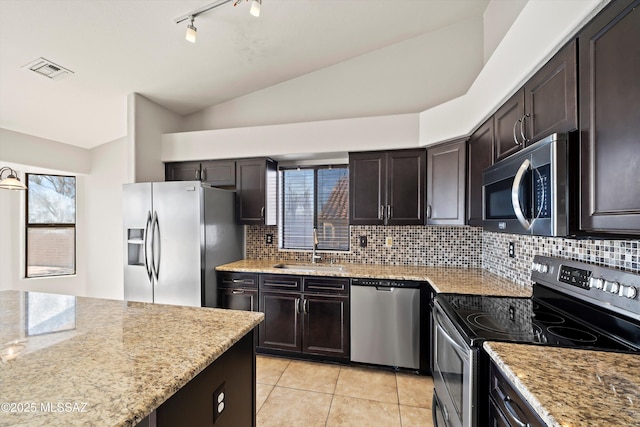 kitchen featuring dark brown cabinetry, stainless steel appliances, a sink, visible vents, and vaulted ceiling