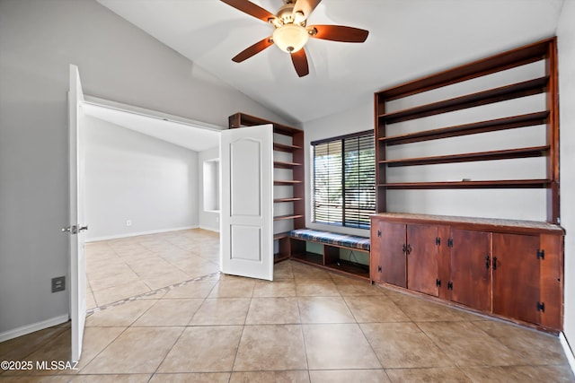 interior space featuring vaulted ceiling, ceiling fan, light tile patterned floors, and baseboards