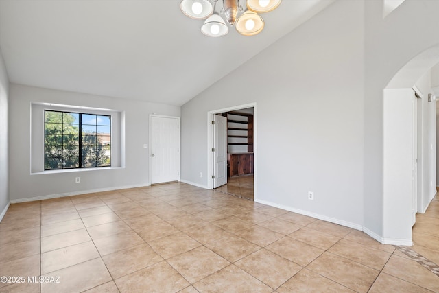 unfurnished room featuring light tile patterned floors, high vaulted ceiling, arched walkways, and baseboards