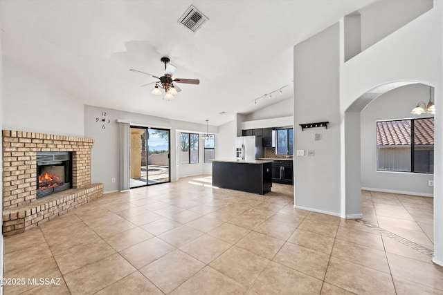 unfurnished living room featuring light tile patterned floors, ceiling fan, a fireplace, and visible vents