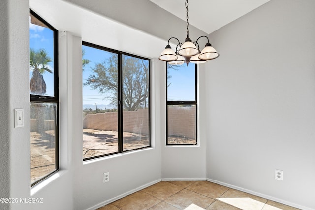 unfurnished dining area featuring an inviting chandelier, vaulted ceiling, baseboards, and light tile patterned floors