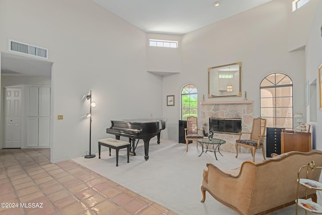 tiled living room with a fireplace and a towering ceiling