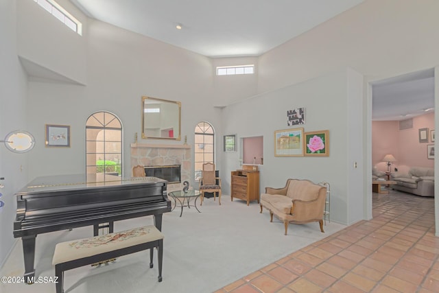 living area featuring a fireplace, a towering ceiling, and light tile patterned flooring