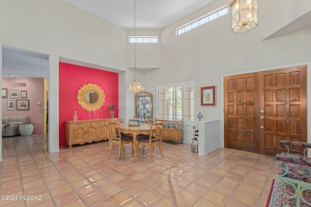 dining room with a towering ceiling and light tile patterned floors