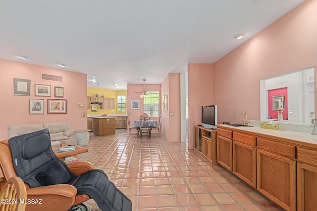 living room with ceiling fan, light tile patterned floors, and sink