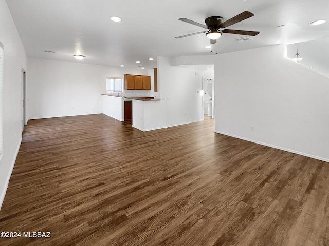 unfurnished living room featuring dark hardwood / wood-style flooring and ceiling fan