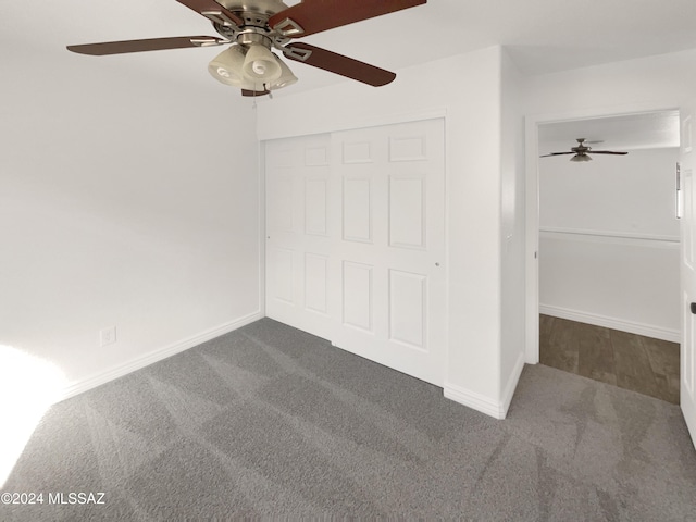 unfurnished bedroom with dark colored carpet, a closet, and ceiling fan