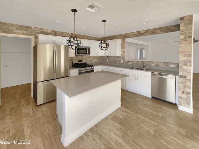 kitchen with white cabinetry, sink, a center island, and stainless steel appliances