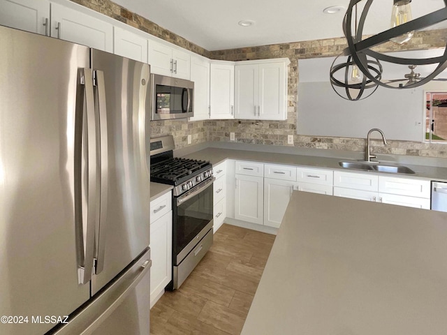 kitchen featuring white cabinets, stainless steel appliances, tasteful backsplash, and sink