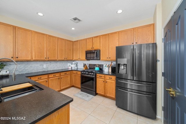 kitchen featuring black appliances, backsplash, light tile patterned floors, and sink