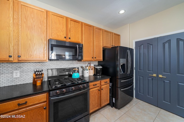 kitchen with appliances with stainless steel finishes, tasteful backsplash, and light tile patterned floors